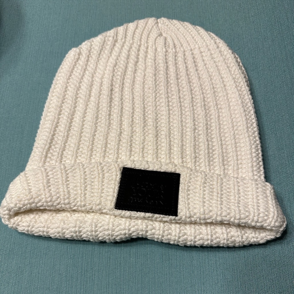 White cuffed Love Your Melon beanie with black patch